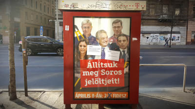 En kampanjposter för Fidesz och mot oppositionen och George Soros. Texten lyder  ungefär "Hjälp oss stoppa Soros hantlangare".