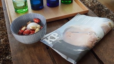 Kyrkpressen tidningen ligger på ett bord vid en skål med påskägg