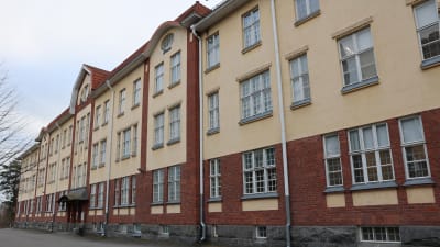 En stor gulbrun stenbyggnad, Åbo stads äldrepsykiatriska avdelning i Kuppis.