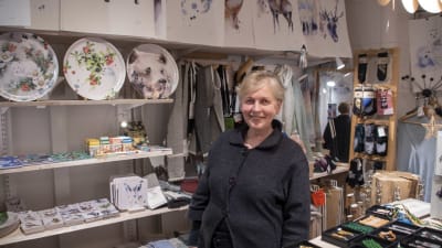 Jaana Silander står i sin butik, omgiven av varor tillverkade i Finland.
