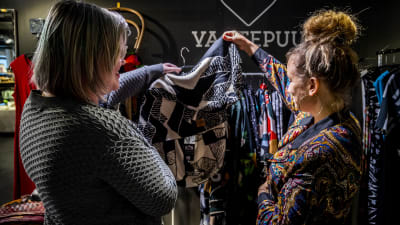 Helena Opas och Lotta Palmgren går igenom kläder i butiken Vaatepuu
