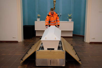 Jouni Manninen visar hur kistan kommer upp till kapellet via en hiss i golvet.
