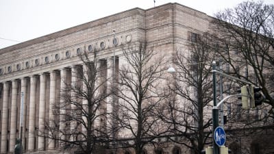 Massivt stenhus med en pelarrad på framsidan. Riksdagshuset i Helsingfors. 