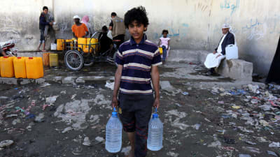 En pojke i Jemens huvudstad San'a håller två dunkar med vatten. Bristen på rent vatten är ett stort problem och har förvärrat koleraepidemin som härjar i landet.