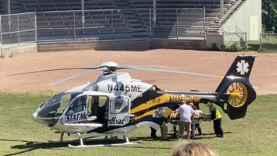 En lälkarhelikopter har landat på en gräsplan. 