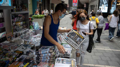 Apple Dailys specialupplaga säljs till en kund vid en kiosk i Hongkong.