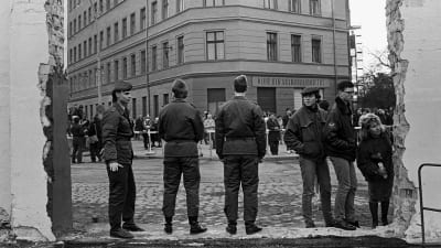 Folk och soldater vid den delvis rivna Berlinmuren vid Bernauerstrasse