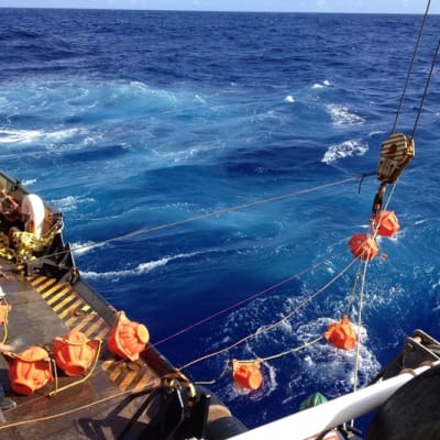 Tutkijat kiskovat tutkimuslaitetta vinssillä laivan kannelle merestä.