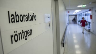 En skylt i en sjukhuskorridor där det står Röntgen på svenska och finska.
