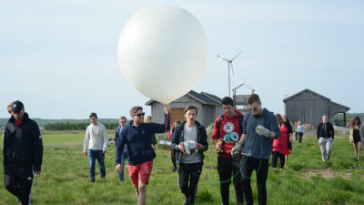 Fyra personer bär på en väderballong, som ska släppas upp vid Meteoria Söderfjärden.