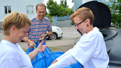 två kvinnor och en man återvinner papper