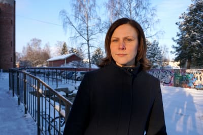 Kvinna i svart jacka tittar in i kameran.