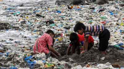 Några barn leker bland skräp o Mumbai, Indien. 