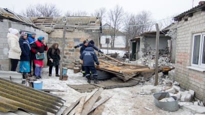 Bybor i Trudove, Donetsk, får hjälp med att riva en byggnad som skadats i granateld 18.2.2017