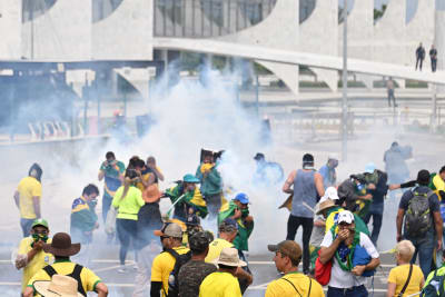 Demonstranter och rökgas i Brasiliens huvudstad Brasília utanför regeringsbyggnaden Palácio do Planalto.