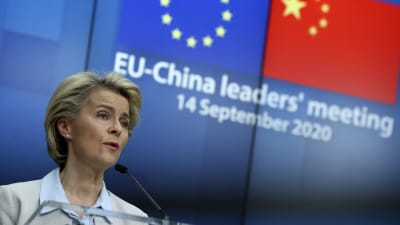 Ursula von der Leyen. I bakgrunden EU:s och Kinas flaggor. 