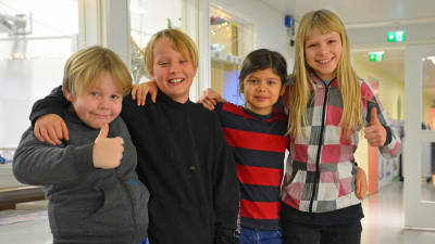 Fyra barn i en skolkorridor.