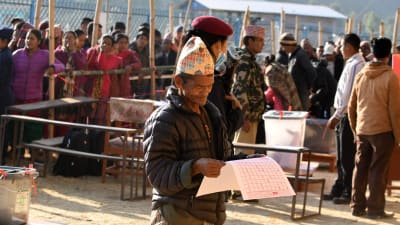En nepalesisk väljare studerar valsedeln i Chautara, ett hundratal kilometer öster om huvudstaden Katmandu.