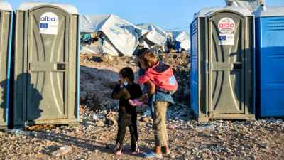 Barn som väntar utanför kemiska toaletter i flyktinglägret Kara Tepe