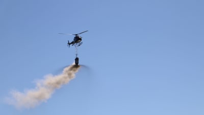 Helikopter sprider ut kalksten i Kolkkaviken i Nådendal. 