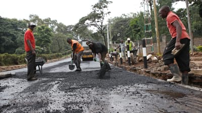 Kenyanska vägarbetare asfalterar en väg inför president Barack Obamas besök i landet i juli 2015.