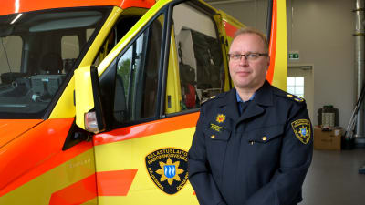 Akutvårdschef poserar framför en ambulans