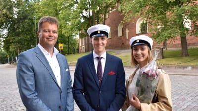 Far och son Österbacka och Irina Grön står utanför Akademihuset.