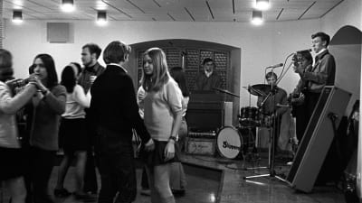 Unga människor dansar och en orkester spelar på 60-talet