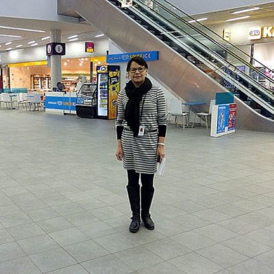 Nainen seisoo kauppakeskuksen aulassa.