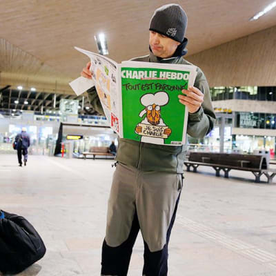 Mies lukee Charlie Hebdo -lehteä Rotterdamin keskusrautatieasemalla.