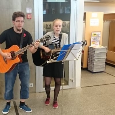 Oulun kaupungin palkkaamat nuoret Pirkka Lepola ja Julia Sundberg esiintyvät kirjaston ala-aulassa
