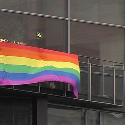 Sateenkaarilippua kiinnitetään Kiasman parvekkeelle.