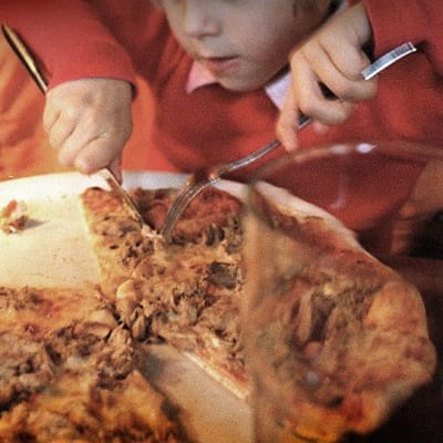 Lapsi syö pizzaa