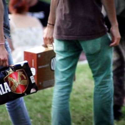 Nuoret kantavat 12-pack olutpakkauksia. 