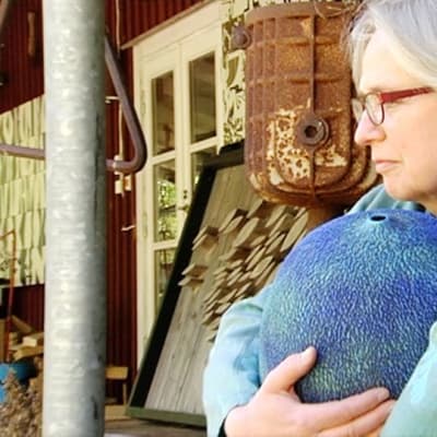 Erna Aaltonen sylissään keraaminen esine.