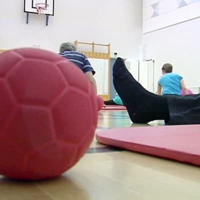 Kuntoutettavia jumppasalissa.