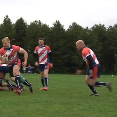 Rugby pelaaja juoksee pallon kanssa.