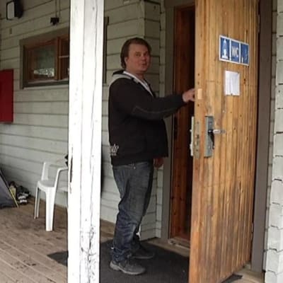 Alhovuoren entinen omistaja Tom Puusa huoltorakennuksen ovella.