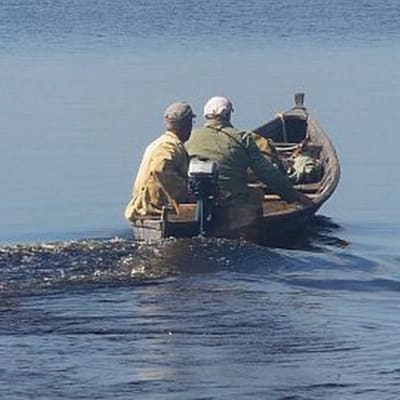 Kaksi miestä veneessä järvellä.