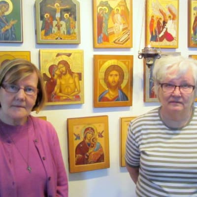 Kaksi naista seisoo ikonien edessä.