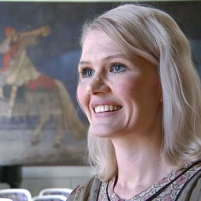 Historioitsija Jenni Kirves ja taustalla Akseli Gallen-Kallelan Kullervon sotaan lähtö -maalaus.