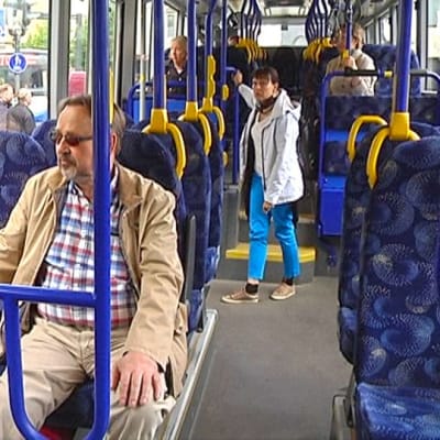Matkustajia bussin kyydissä.