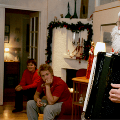 Joulupukki soittaa haitaria perheelle jouluaattona.