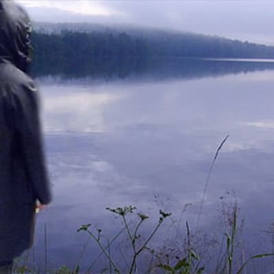 Hahmo seisoo järven rannalla.