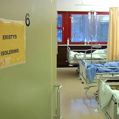 Kuvassa terveyskeskussairaalan huone, jonka ovessa on erityksestä kertova ilmoitus