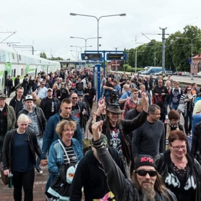 Ihmisiä astuu ulos junasta Hämeenlinnan asemalla