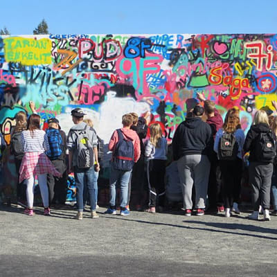 Tornion Putaan koulun oppilaita maalaamassa graffitiseinää.