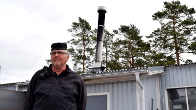 På bilden Rune Råberg som är sotare och i bakgrunden en skorsten.