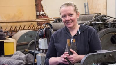 Alicia Trezise-Segervall håller spolar med spunnet garn.