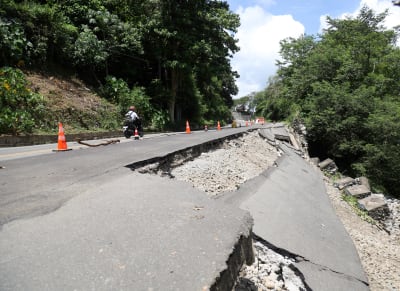 Asfaltbeläggningen på en väg har skadats i ett jordskalv.